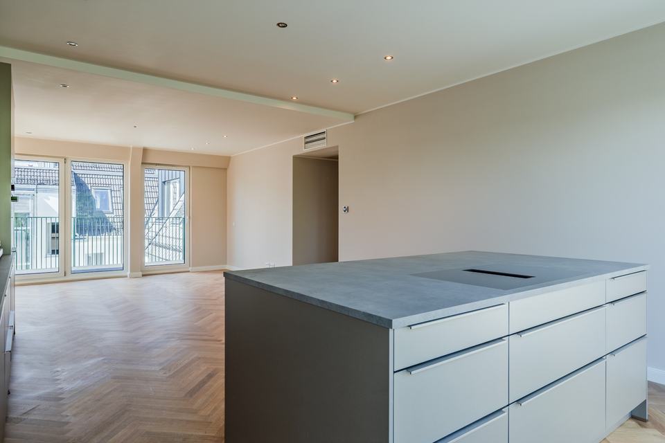 Wohnraum mit Kochinsel und Fischgrätparkett
